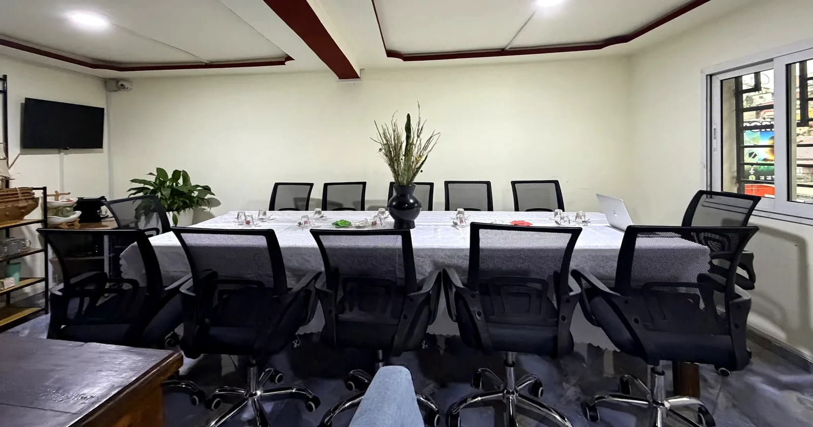 La salle de réunion QUALITEC à Fianarantsoa : une grande table, douze chaises, un écran mural.
